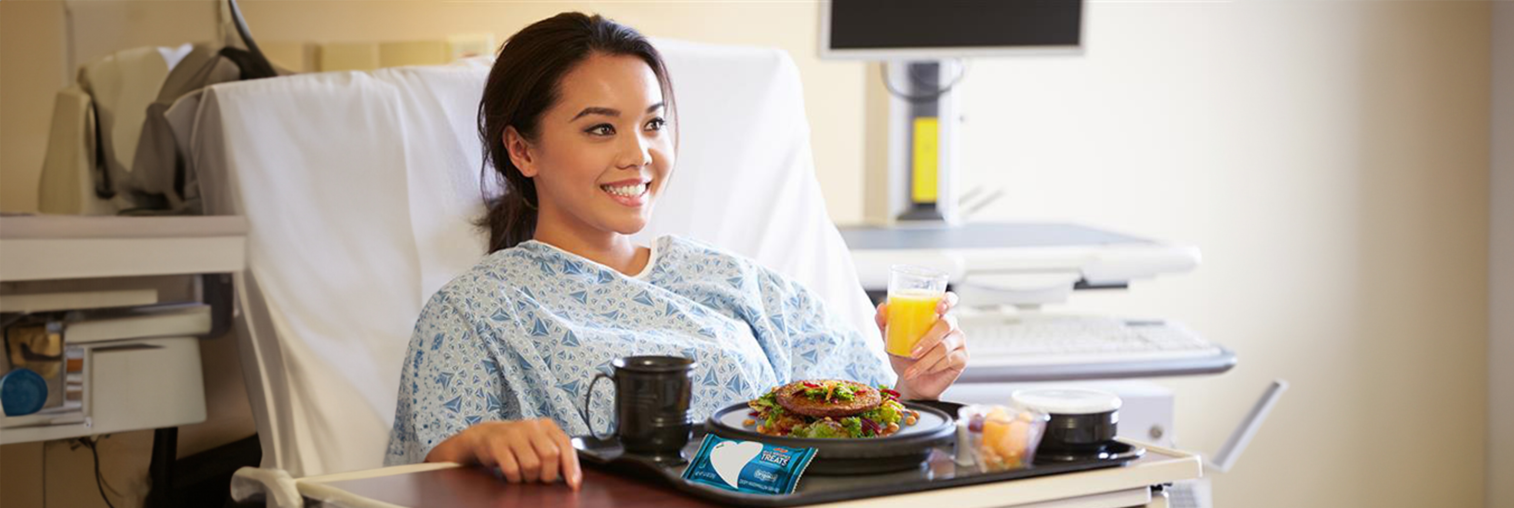 An female patient with a tray of food that includes a Rice Krispies Treats® original bar