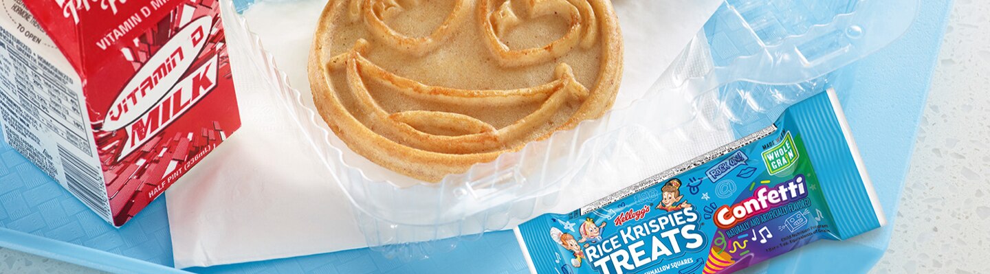 Milk, Emoji Waffle, and Rice Krispies Treats on a blue table