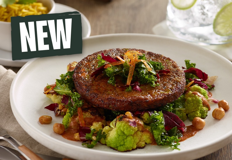 close up a Morningstar <sup>®</sup>plant-based royal thai veggie burger with visible veggies like green peas, red and green bell peppers, kale, broccoli, and more.